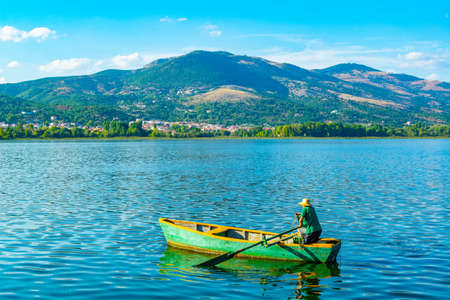 KASTORIA, GREECE, SEPTEMBER 10, 2017: fisherman in a boat on lake orestiada/kastoria in Greeceのeditorial素材