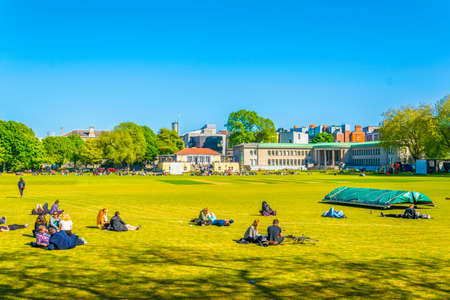 DUBLIN, IRELAND, MAY 9, 2017: Students are having a picnic on a field inside of the trinity college in Dublin, Irelandのeditorial素材
