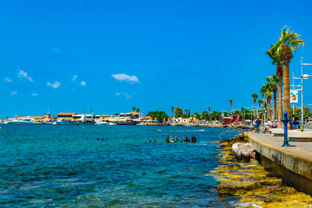 PAPHOS, CYPRUS, AUGUST 18, 2017: People are enjoying a sunny day on a seaside promenade in Paphos, Cyprusのeditorial素材