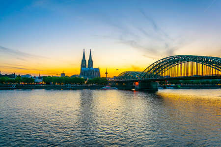 Sunset view of the cathedral in Cologne and Hohenzollern bridge over Rhein, Germanyの写真素材