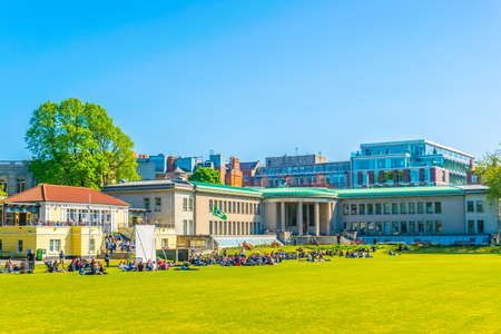 Students are having a picnic on a field inside of the trinity college in Dublin, Irelandのeditorial素材