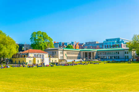Students are having a picnic on a field inside of the trinity college in Dublin, Irelandのeditorial素材