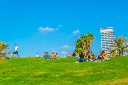TEL AVIV, ISRAEL, SEPTEMBER 10, 2018: People are sitting on a meadow near beach in Tel Aviv, Israelのeditorial素材