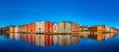 Colorful timber houses surrounding river Nidelva in the Brygge district of Trondheim, Norway