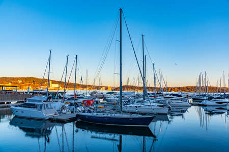 Motor boats mooring in a channel between residential buildings at Aker Brygge, Oslo, Norwayの写真素材