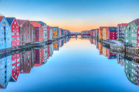 Sunset view of colorful timber houses surrounding river Nidelva in the Brygge district of Trondheim, Norwayの写真素材