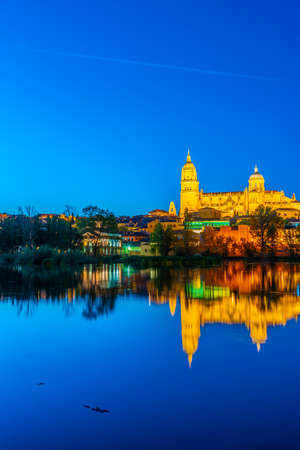 Sunset view of Cathedral at Salamanca reflected on river Tormes, Spainの写真素材