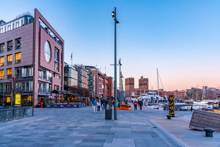OSLO, NORWAY, APRIL 15, 2019: Town hall in oslo viewed behind Stranden waterfront during sunset, Norwayの写真素材