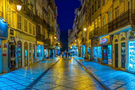 COIMBRA, PORTUGAL, MAY 20, 2019: Night view of people strolling through boulevard Ferreira Borges at central Coimbra, Portugalの写真素材