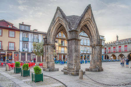 GUIMARAES, PORTUGAL, MAY 23, 2019: People are strolling in front of the church of our lady of Oliveira in the old town of Guimaraes, Portugalのeditorial素材