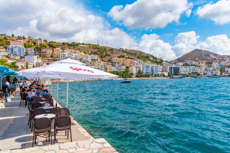 SARANDE, ALBANIA, SEPTEMBER 26, 2019: People are sitting at a seaside restaurant at Sarande, Albaniaの写真素材