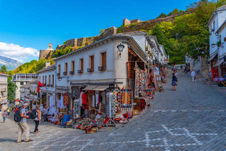 GJIROKASTER, ALBANIA, SEPTEMBER 25, 2019: People are strolling through old town of Gjirokaster,...