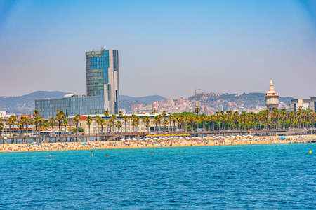 People are enjoying a sunny day on Barceloneta beach in Barcelona, Spainの写真素材