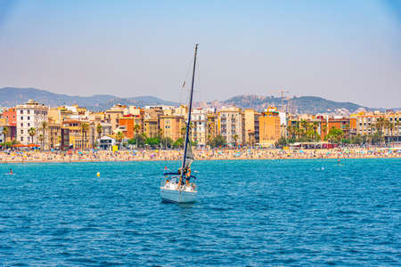 People are enjoying a sunny day on Barceloneta beach in Barcelona, Spainの写真素材