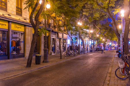 VALENCIA, SPAIN, JUNE 17, 2019: Night view of a narrow street in the center of Valencia, Spain