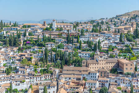 People are admiring Alhambra from viewpoint of San Nicolas in Granada, Spain
