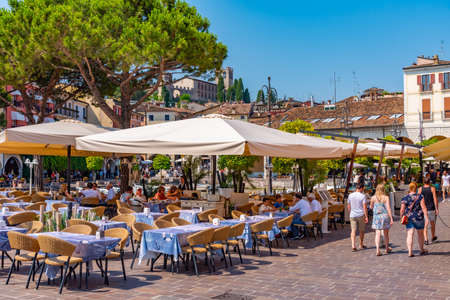 DESENZANO DEL GARDA, ITALY, JULY 21, 2019: People are dinning at Desenzano del Garda in Italyのeditorial素材
