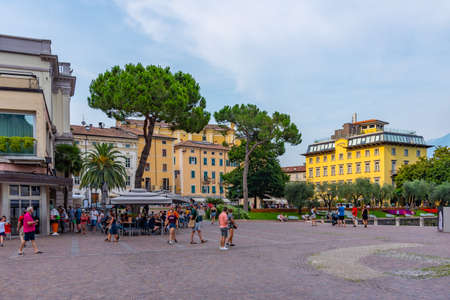 RIVA DEL GARDA, ITALY, JULY 22, 2019: People are strolling at Piazza Cesare Battisti in Riva del...