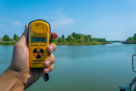 PRIPYAT, UKRAINE, AUGUST 30, 2019: Male hand measuring radioactivity near Pripyat river in the Ukraineのeditorial素材