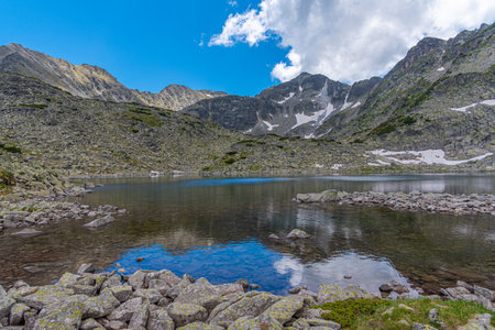 Musala peak mirroring at a surface of a mountain lake in bulgaria