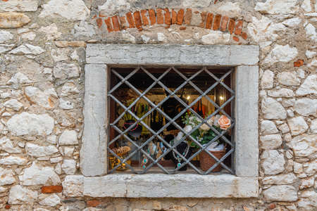 Jewelery displayed behind a steel bar in a stone house