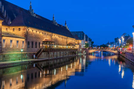 Sunset view of the waterfront of a channel passing ancienne douanne building in Strasbourg, Franceのeditorial素材