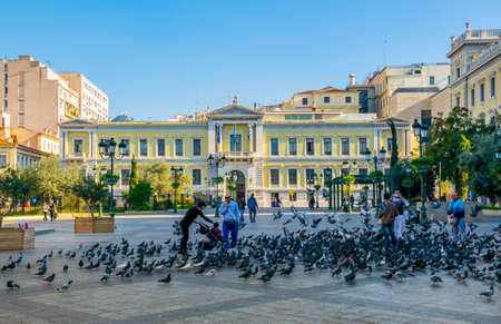 ATHENS, GREECE, DECEMBER 10, 2015: People are feeding pigeons on the kotzia square in front of the city hall of athens.のeditorial素材