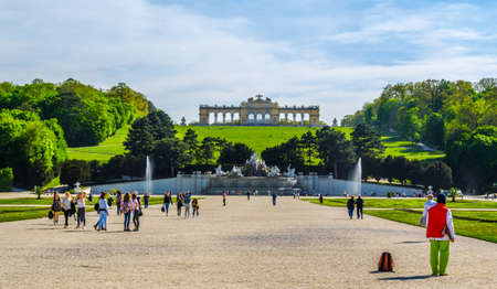 VIENNA, AUSTRIA, APRIL 30, 2015: View of green Flowerbed, People going towards The Neptune Fountain and Gloriette at the Schonbrunn, Vienna, Austriaのeditorial素材
