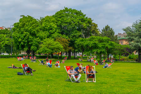 VIENNA, AUSTRIA, JUNE, 2016: people are enjoying a sunny day on a lawn in front of the votivkirche church in Vienna.のeditorial素材