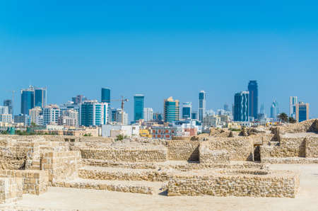 MANAMA, BAHRAIN, OCTOBER 22, 2016: View of the Bahrain fort complex with the Qal'At Al Bahrain fort with modern skyscrapers visible at horizon.のeditorial素材