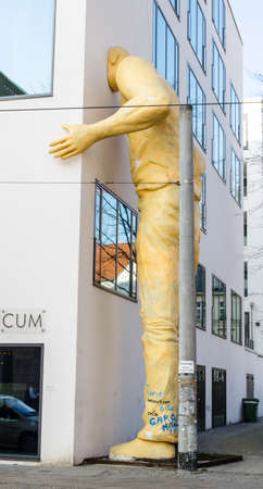 BERLIN, GERMANY, MARCH 12, 2015: statue of a man hiding his head in a building in berlin.のeditorial素材