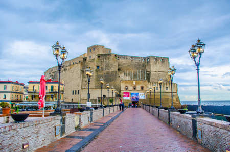 NAPLES, ITALY, MAY 14, 2014: people are passing around of the Castel dell'Ovo (Egg Castle) a medieval fortress in the bay of Naples, Italyのeditorial素材