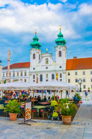 GYOR, HUNGARY MAY 20, 2016: People are walking in front of the Benedictine Loyolai Szent Ignac Church on szechenyi square in Gyor, Hungaryのeditorial素材