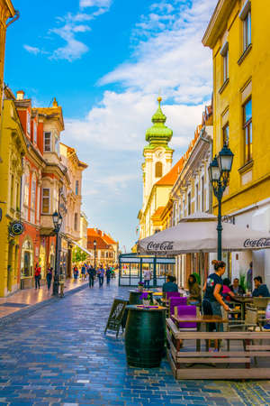 GYOR, HUNGARY MAY 20, 2016: People are walking through a narrow street in old town of the hungarian...