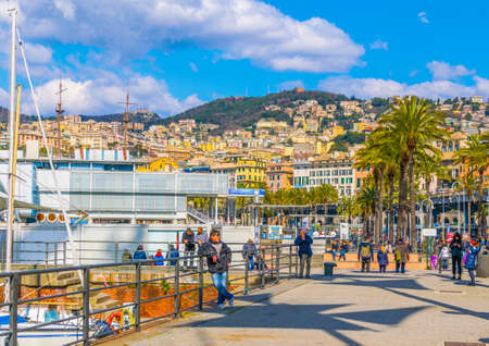 GENOA, ITALY, MARCH 13, 2016: people are strolling over seaside promenade leading through port of genoa. The port offers various attractions for tourists like the european biggest aquarium.のeditorial素材