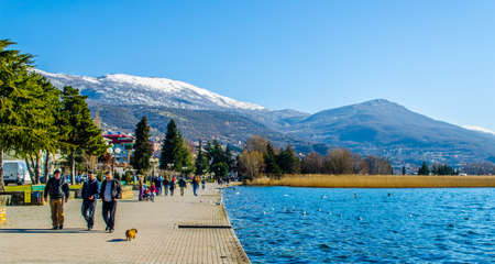 OHRID, FEBRUARY 14, 2015: people are strolling ona lakeside promenade next to the ohrid lake during sunny day in february.のeditorial素材