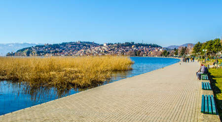 OHRID, FEBRUARY 14, 2015: people are strolling ona lakeside promenade next to the ohrid lake during sunny day in february.のeditorial素材