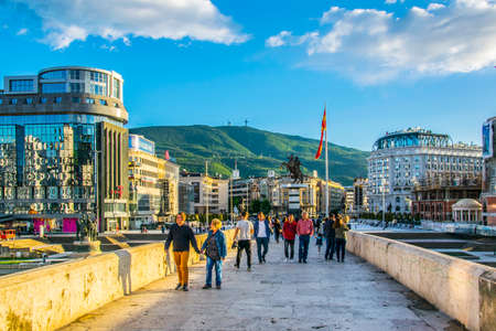 SKOPJE, MACEDONIA, MAY 14, 2016: People are passing over the ancient stone bridge in the macedonian capital skopje leading to the macedonia square dominated by statue of alexander the great.のeditorial素材