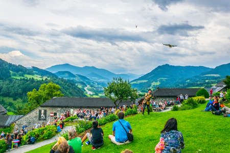 WERFEN, AUSTRIA, JULY 2, 2016: Dozens of tourists are watching falconry exhibition taking place at the Hohenwerfen castle in Austria.のeditorial素材