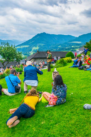 WERFEN, AUSTRIA, JULY 2, 2016: Dozens of tourists are watching falconry exhibition taking place at the Hohenwerfen castle in Austria.のeditorial素材