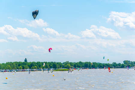 PODERSDORF, AUSTRIA, JULY 9, 2016: Young people are kite surfing on the neusiedlersee lake in Austria near Podersdorf am See town.のeditorial素材