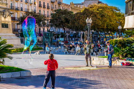 TARRAGONA, SPAIN, DECEMBER 29, 2015: a group of street performers is making soap bubbles in order to amuse people passing byのeditorial素材
