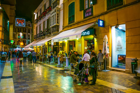 MALAGA, SPAIN, JANUARY 4, 2016: crowds of tourists are strolling through the historical center of malaga after sunsetのeditorial素材