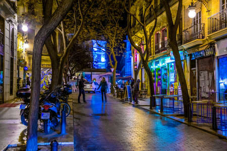 VALENCIA, SPAIN, DECEMBER 31, 2015: people are walking through a narrow street in the old town center of spanish city valencia.のeditorial素材
