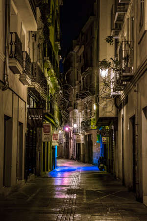 VALENCIA, SPAIN, DECEMBER 31, 2015: people are walking through a narrow street in the old town center of spanish city valencia.のeditorial素材