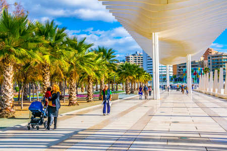 MALAGA, SPAIN, JANUARY 4, 2016: people are walking on the paseo del muelle dos promenade in spanish city malaga which stretches through port under a construction resembeling white waveのeditorial素材