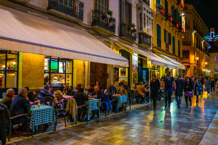 MALAGA, SPAIN, JANUARY 4, 2016: crowds of tourists are strolling through the historical center of malaga after sunsetのeditorial素材