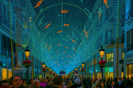 MALAGA, SPAIN, JANUARY 4, 2016: people are walking under christmas / new year decoration in shape of a light tunnel in the historical center of malagaのeditorial素材
