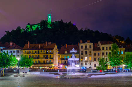 LJUBLJANA, SLOVENIA, JULY 29, 2015: Novi trg - New city square in the slovenian capital Ljubljana is overlooked by a castle situated on a hill across ljubljanica river during a night in July.のeditorial素材