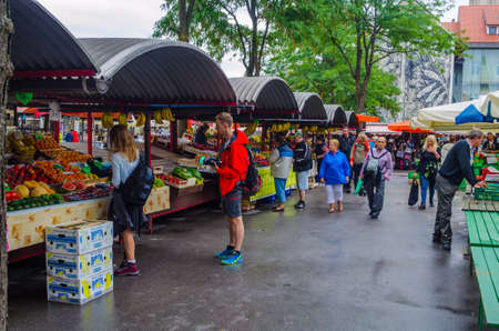 LJUBLJANA, SLOVENIA, JULY 29, 2015: People are strolling among stands in the central market of the slovenian capital Ljubljana and buy various products often from local farmers.のeditorial素材